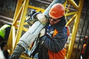 Construction worker carrying large pipe | Workers' Compensation